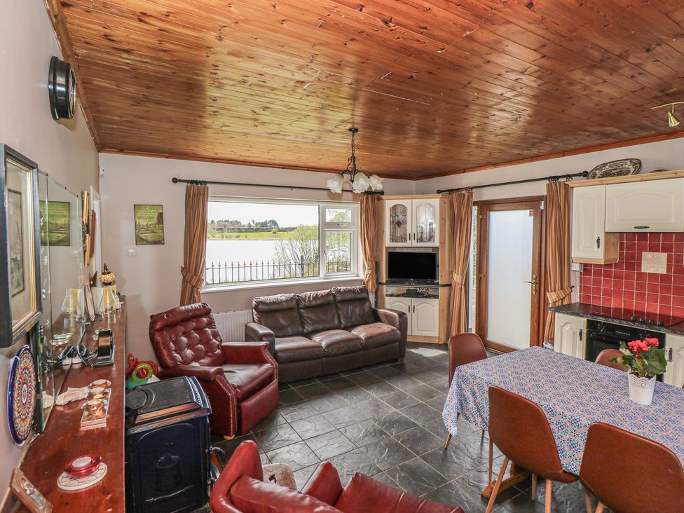 A living room with a sofa, armchairs, and a dining table at Sweetbriar Lodge, Castlerea