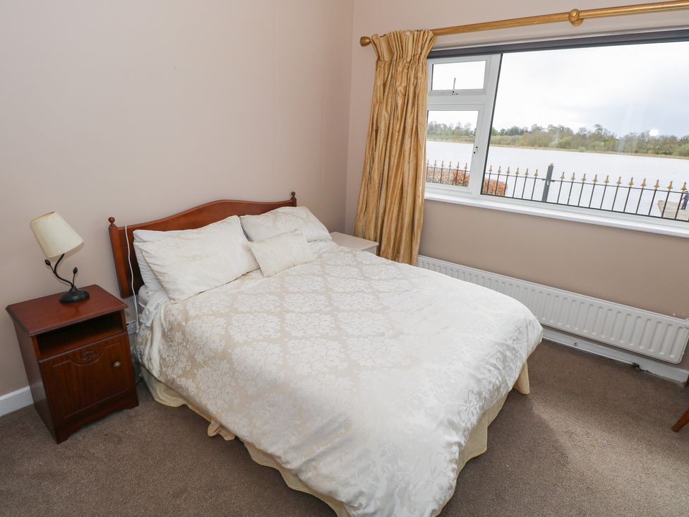 A bedroom with a bed and a window at Sweetbriar Lodge in Castlerea