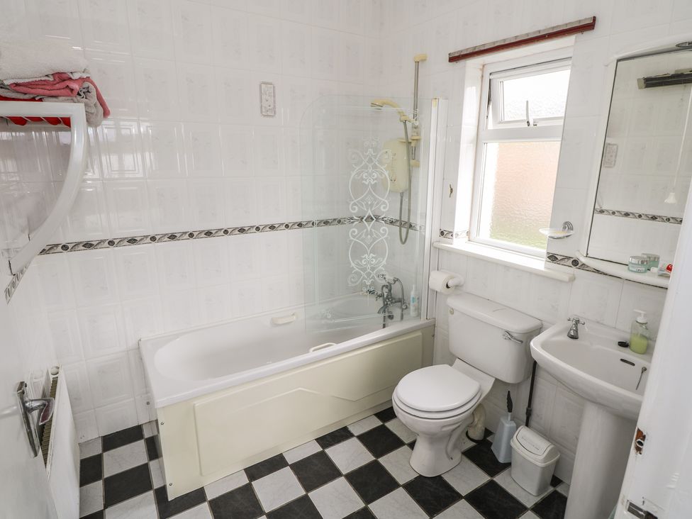 A bathroom with bathtub, toilet, sink, and towel rack at Sweetbriar Lodge in Castlerea
