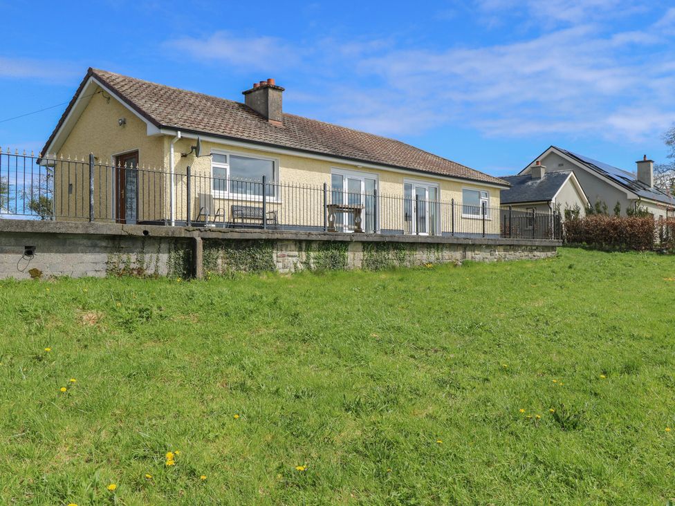 A house with a fence and grass in front at Sweetbriar Lodge Castlerea