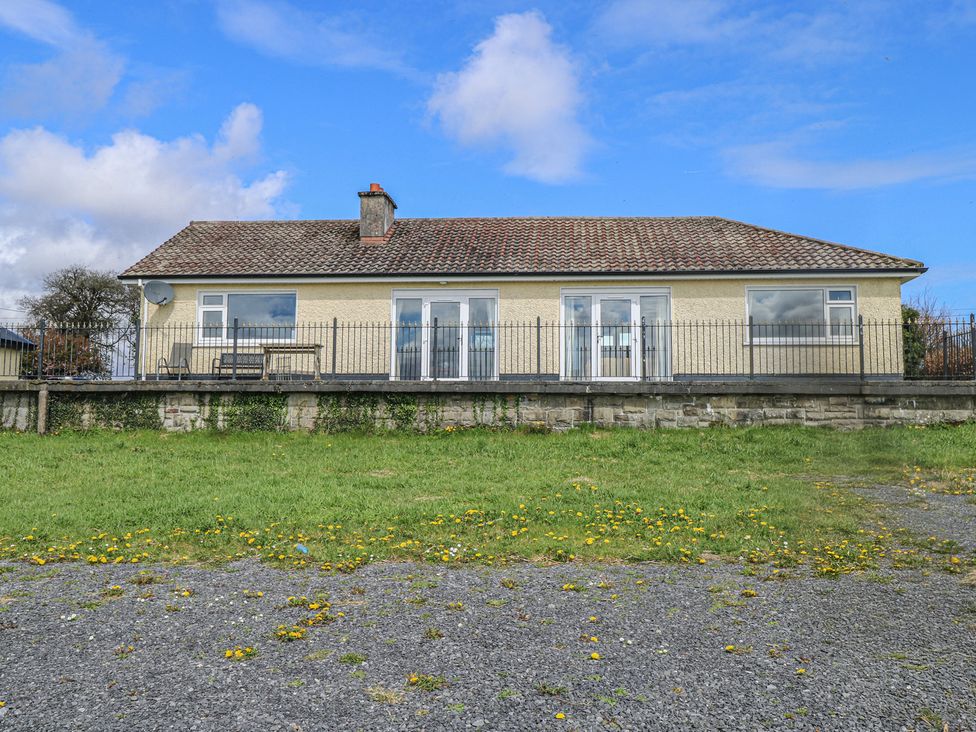 A house with a front porch and fence at Sweetbriar Lodge in Castlerea