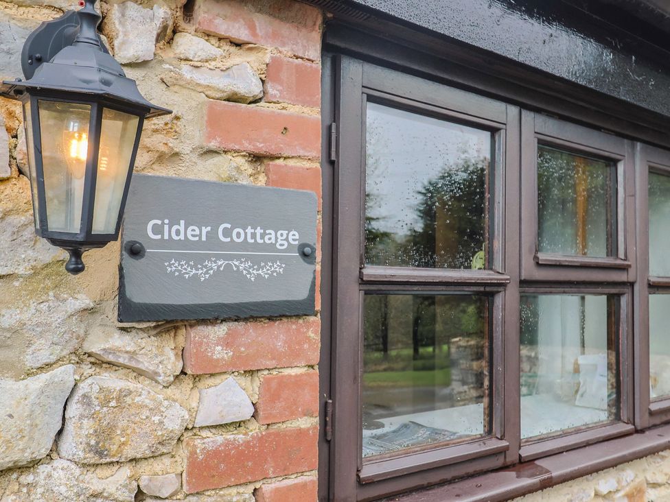 Cider Cottage sign with lamp and window at Cider Cottage in Hawkchurch
