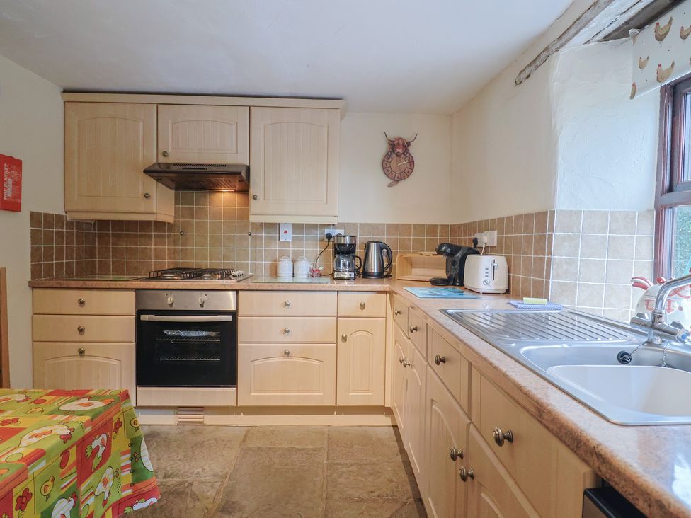 A kitchen with appliances and cabinets at Cider Cottage in Hawkchurch