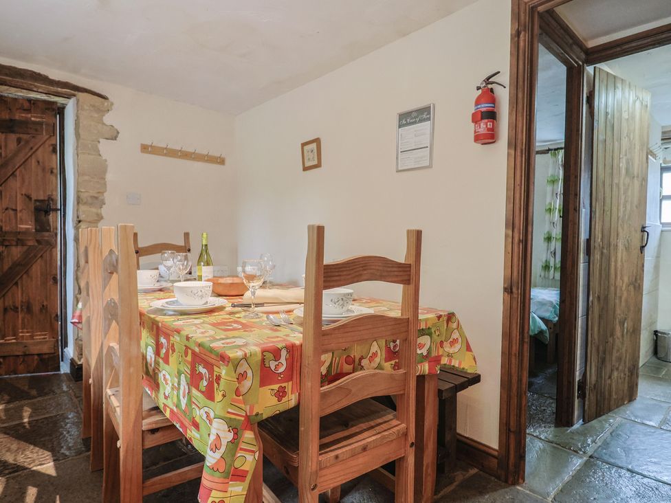 A dining room with a table and chairs at Cider Cottage in Hawkchurch
