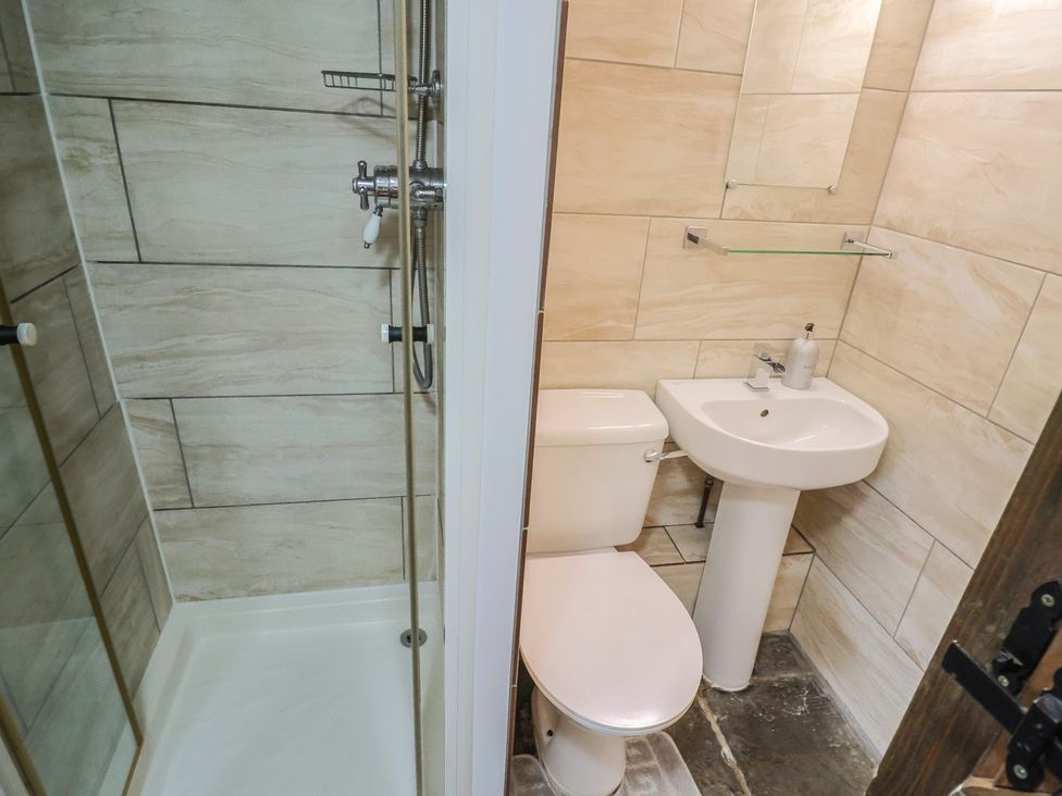 A bathroom with a shower, toilet, and sink at Cider Cottage in Hawkchurch