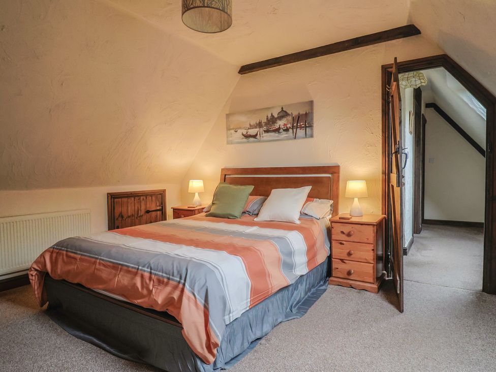 A bedroom with a bed and chest of drawers at Cider Cottage in Hawkchurch