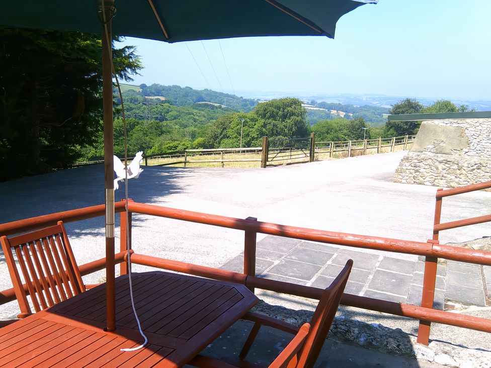 An outdoor area with a table and umbrella at Cider Cottage in Hawkchurch
