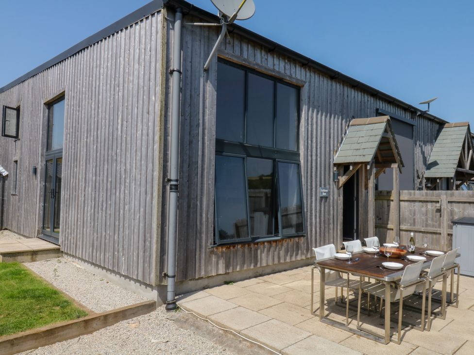 An outdoor dining area with a table and chairs at Fieldstone Barn North Tawton