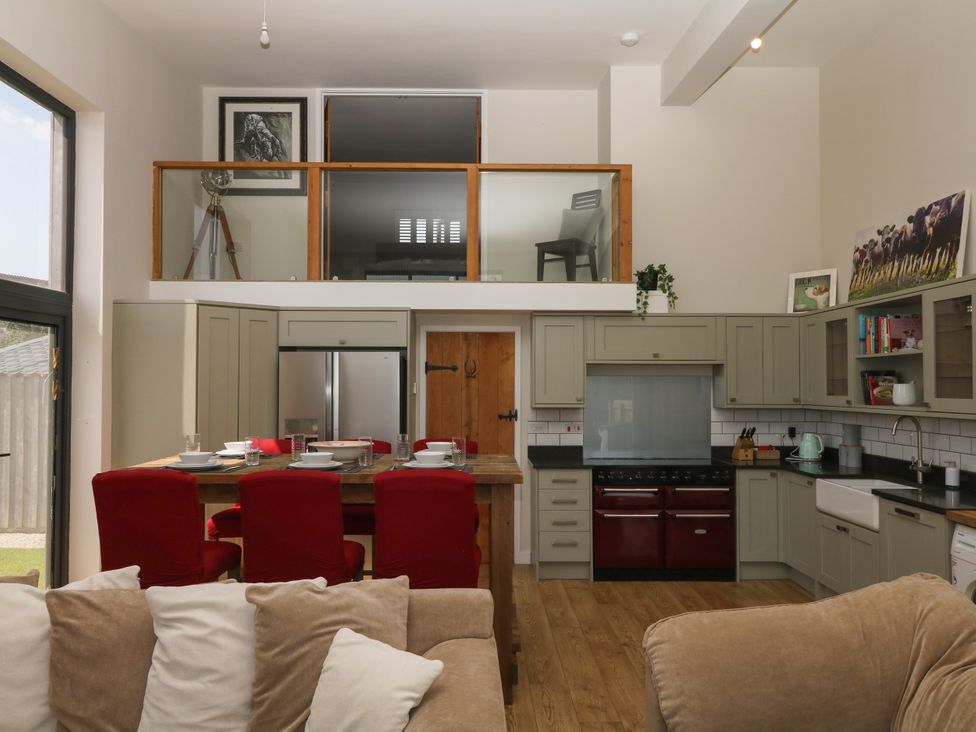 A kitchen with dining table and stools at Fieldstone Barn North Tawton