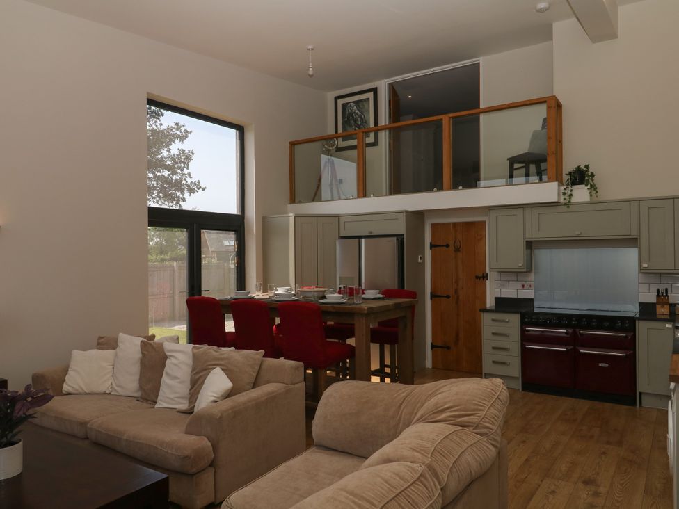 A living room with a sofa and dining area at Fieldstone Barn in North Tawton