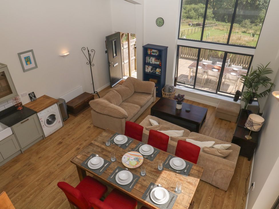 A living room with a sofa and dining area at Fieldstone Barn North Tawton