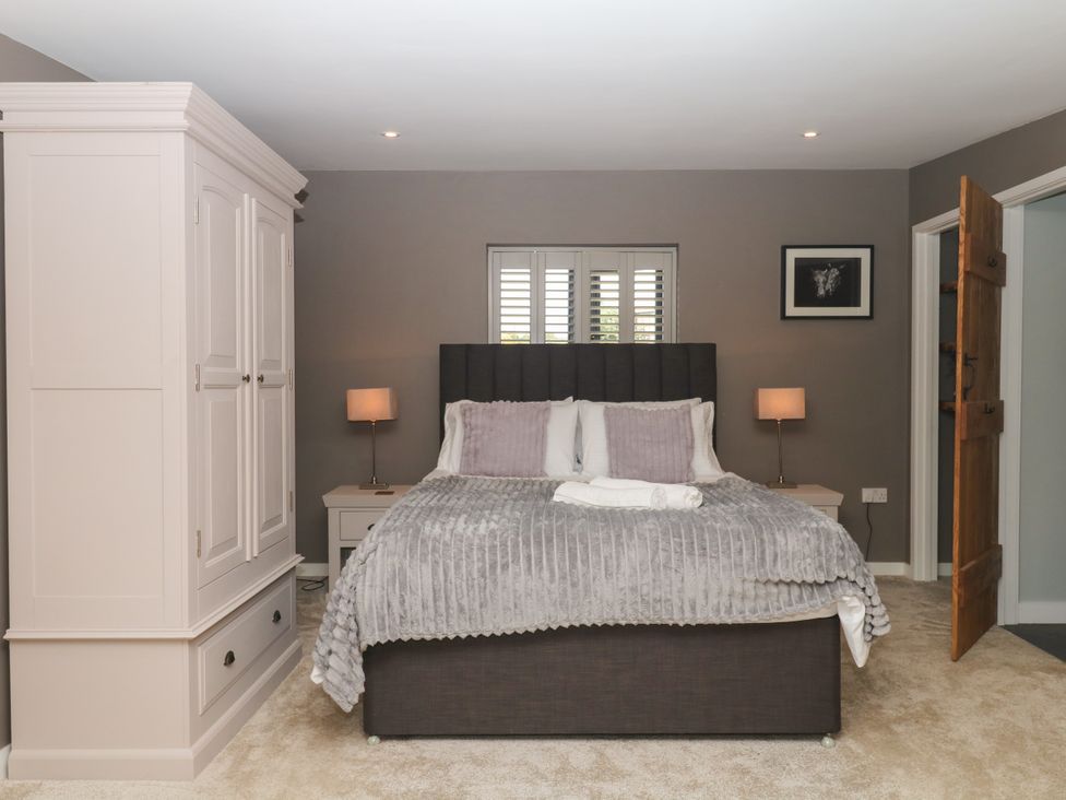 A bedroom with a bed and wardrobe at Fieldstone Barn North Tawton