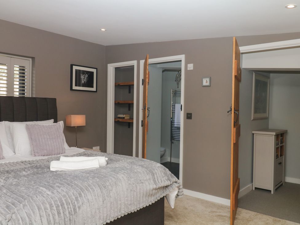 A bedroom with a bed and shelves at Fieldstone Barn in North Tawton