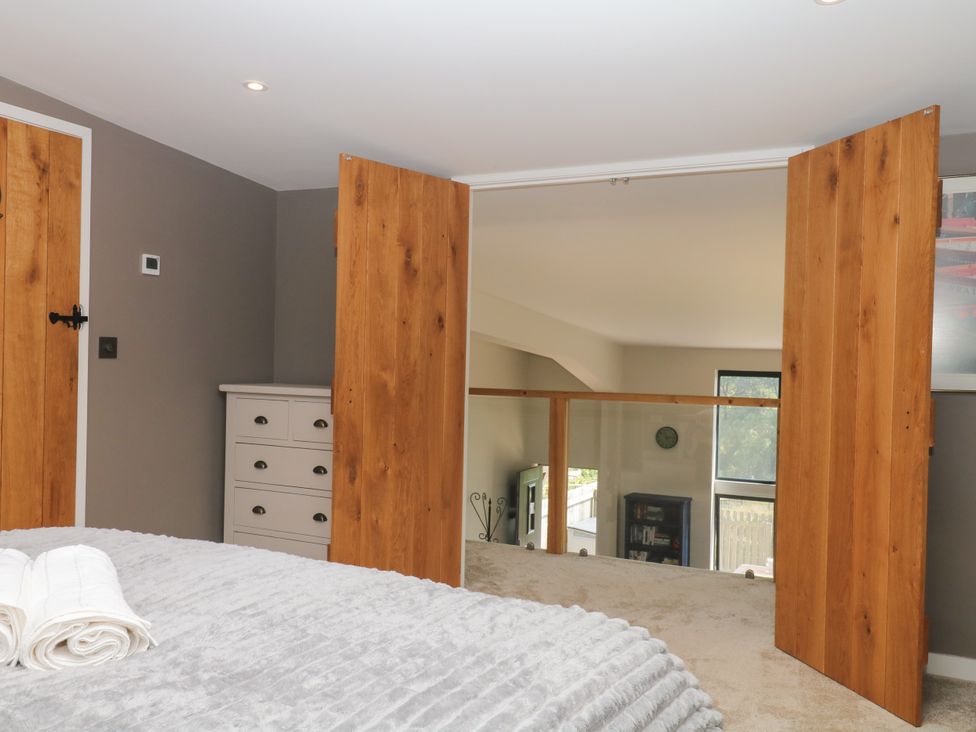 A bedroom with wardrobe and towels at Fieldstone Barn North Tawton