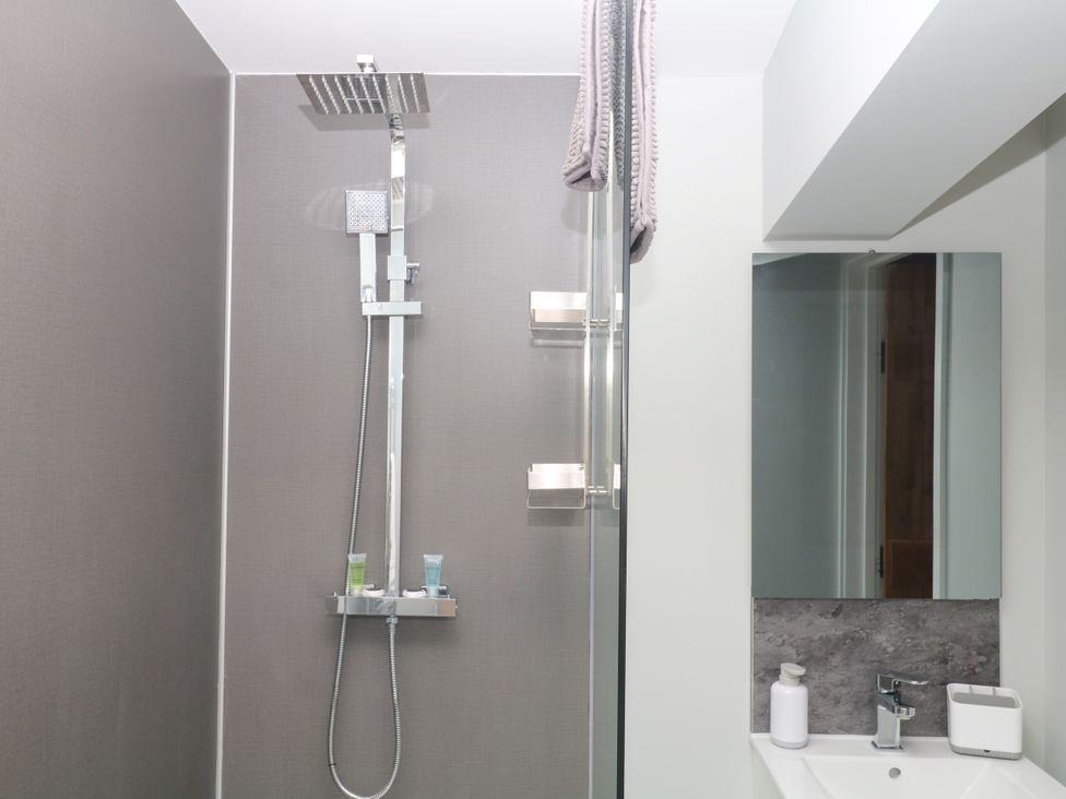 A bathroom with a shower and mirror at Fieldstone Barn North Tawton