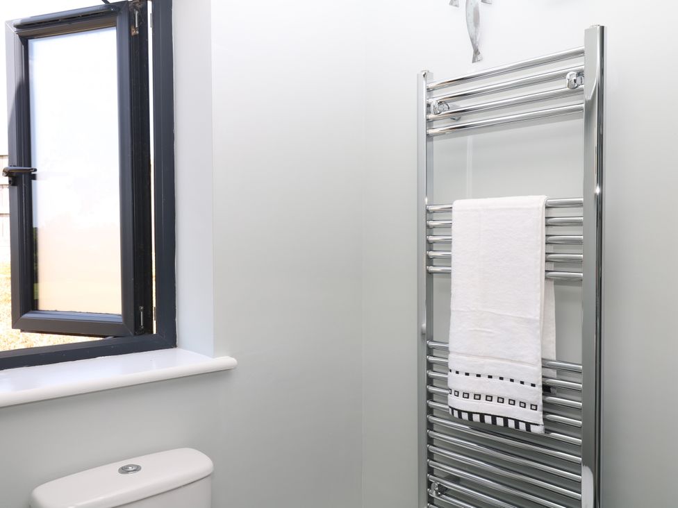 A bathroom with a heated towel rail and window at Fieldstone Barn in North Tawton