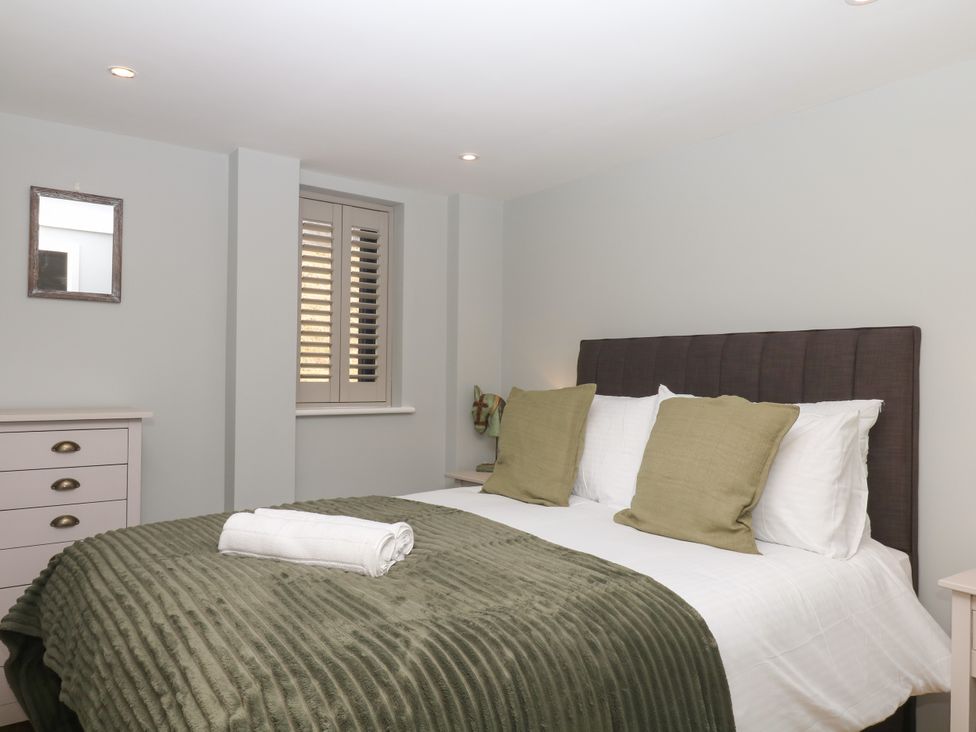 A bedroom with a bed and furniture at Fieldstone Barn North Tawton