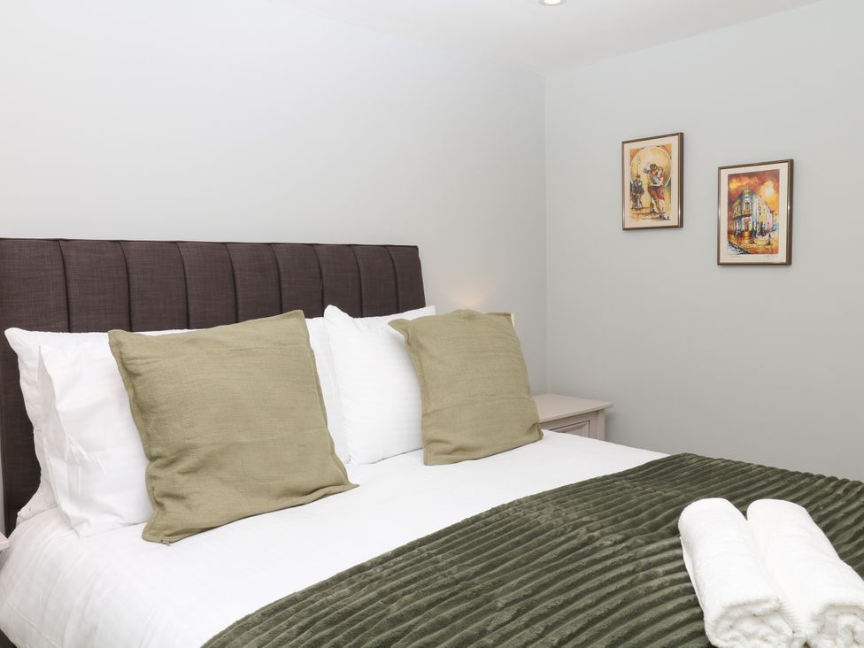 A bedroom with a bed, pillows, and wall art at Fieldstone Barn in North Tawton