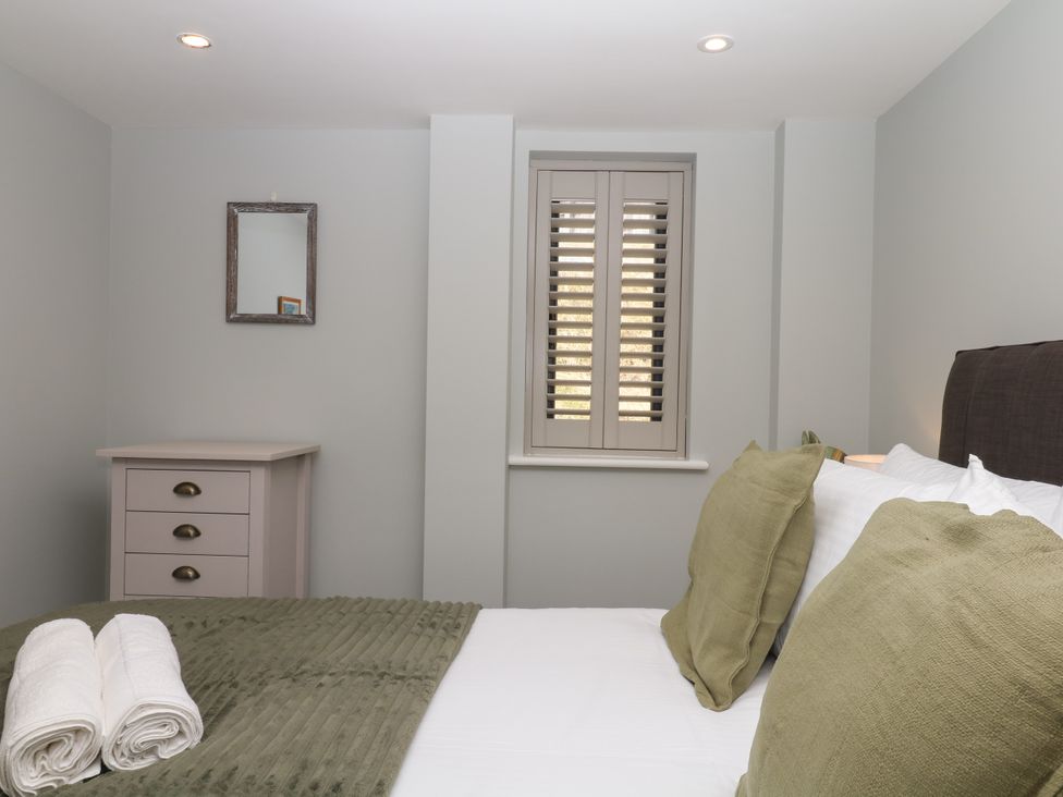 A bedroom with a bed and dresser at Fieldstone Barn North Tawton