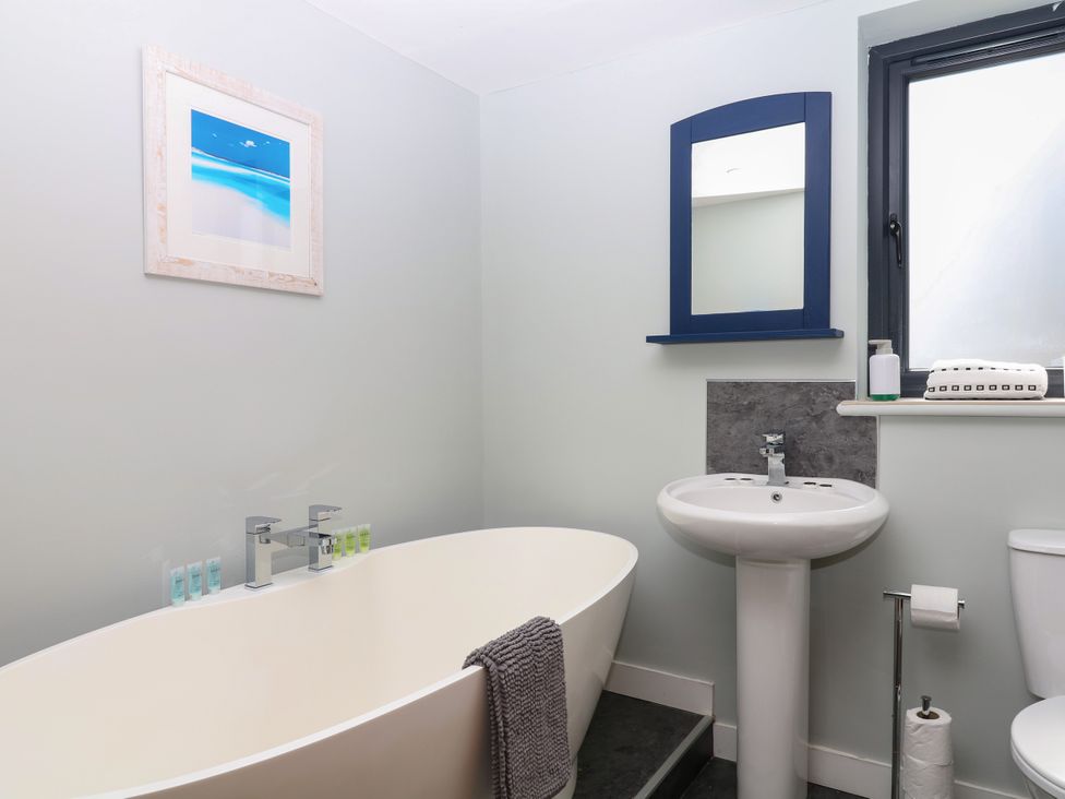 A bathroom with a bathtub and sink at Fieldstone Barn North Tawton