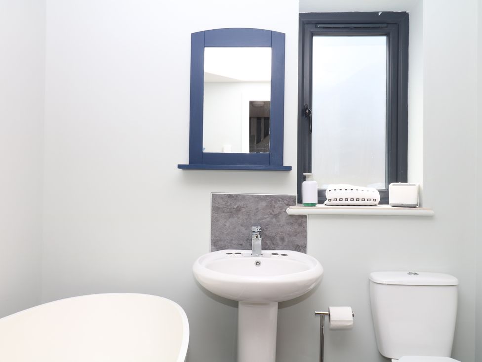 A bathroom with a bathtub, sink, and toilet at Fieldstone Barn in North Tawton