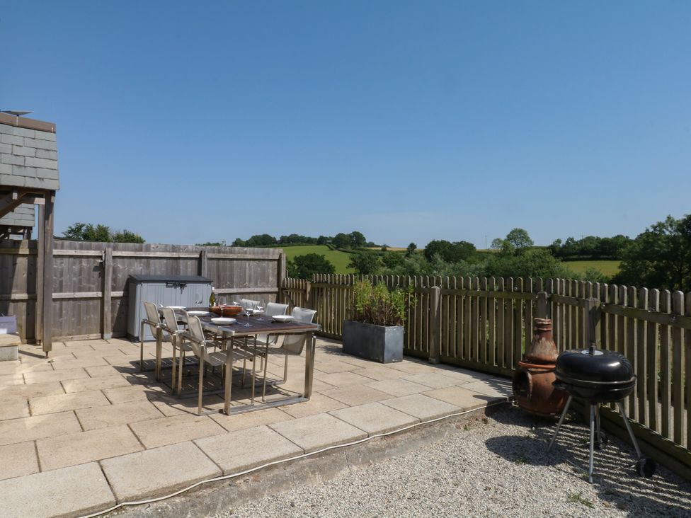 An outdoor patio with a table and chairs at Fieldstone Barn in North Tawton