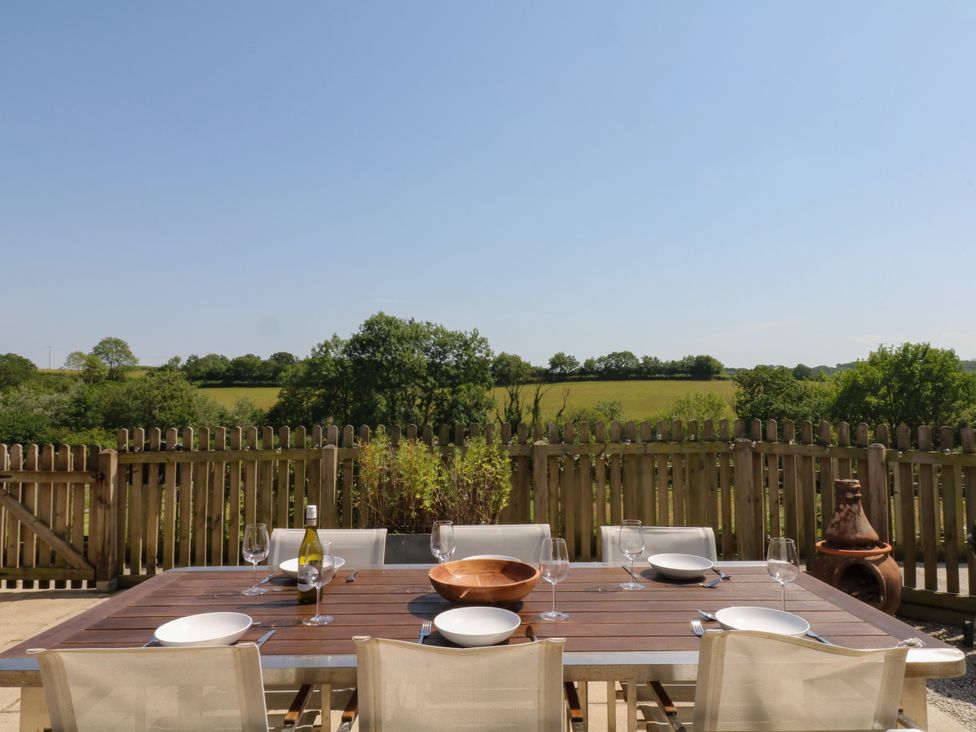 An outdoor dining area with a table and chairs at Fieldstone Barn in North Tawton