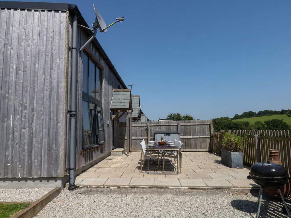 An outdoor dining area with a table and chairs at Fieldstone Barn in North Tawton