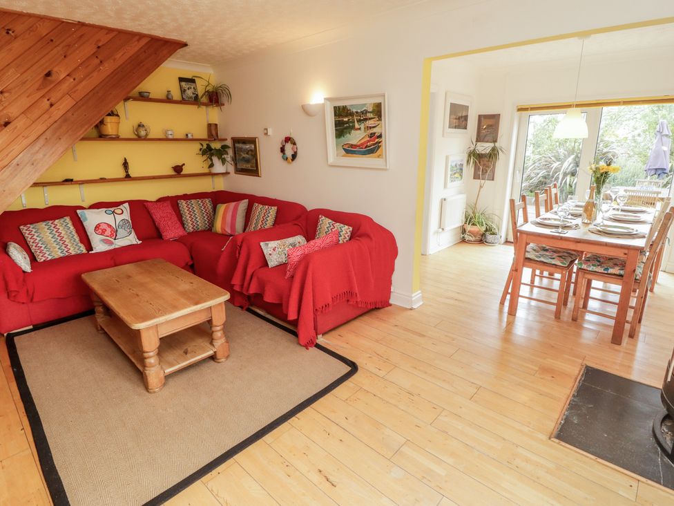 A living room with a sofa and dining area at 1 Rosemount Garden Villas in Tenby