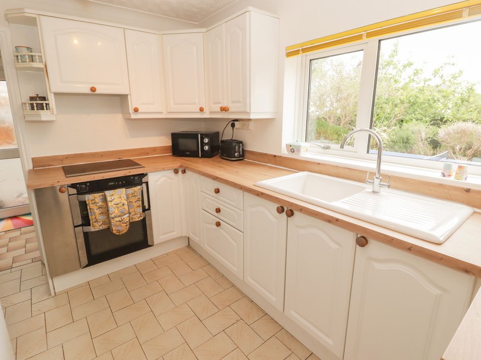 A kitchen with a sink and oven at 1 Rosemount Garden Villas Tenby