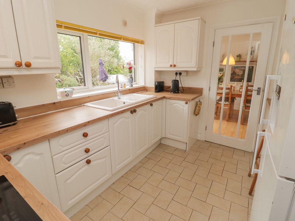 A kitchen with sink and cabinets at 1 Rosemount Garden Villas in Tenby