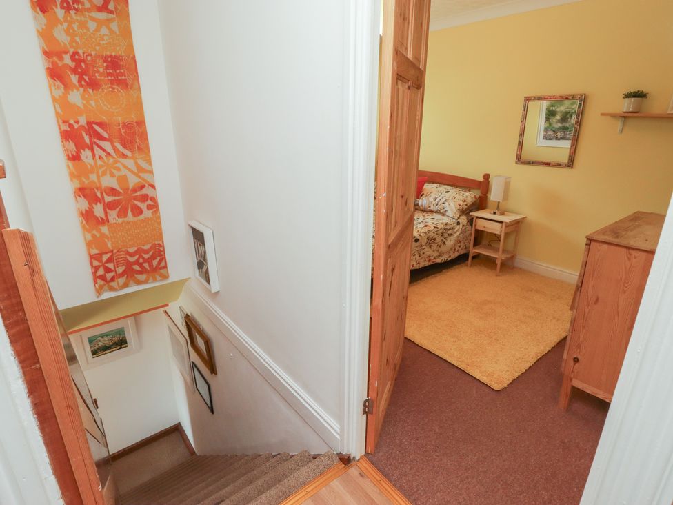 A bedroom with a bed and a bedside table at 1 Rosemount Garden Villas Tenby