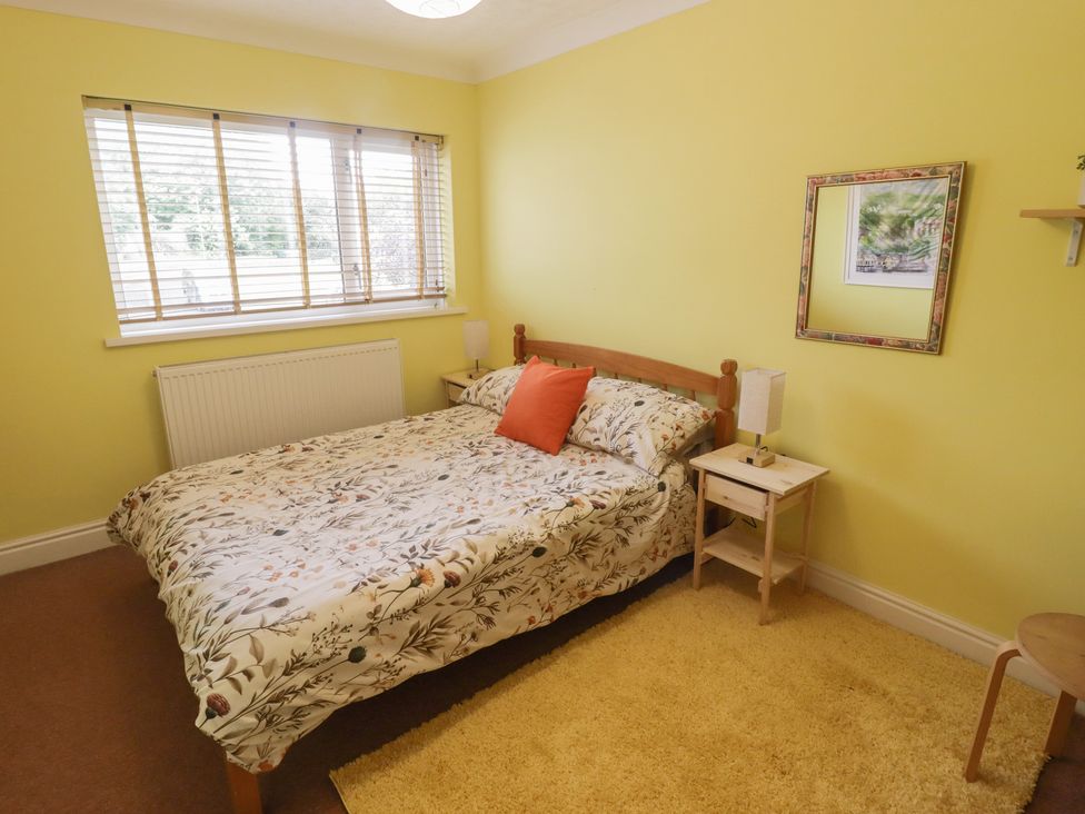 A bedroom with a bed and bedside table at 1 Rosemount Garden Villas Tenby