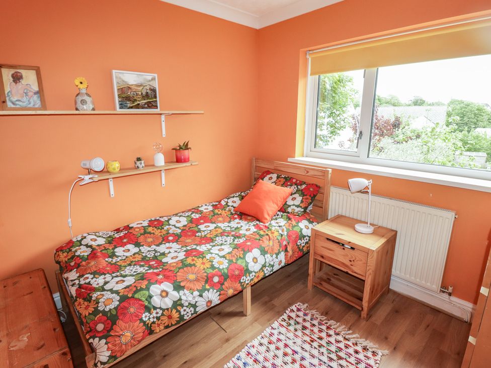 A bedroom with a bed and shelves at 1 Rosemount Garden Villas, Tenby