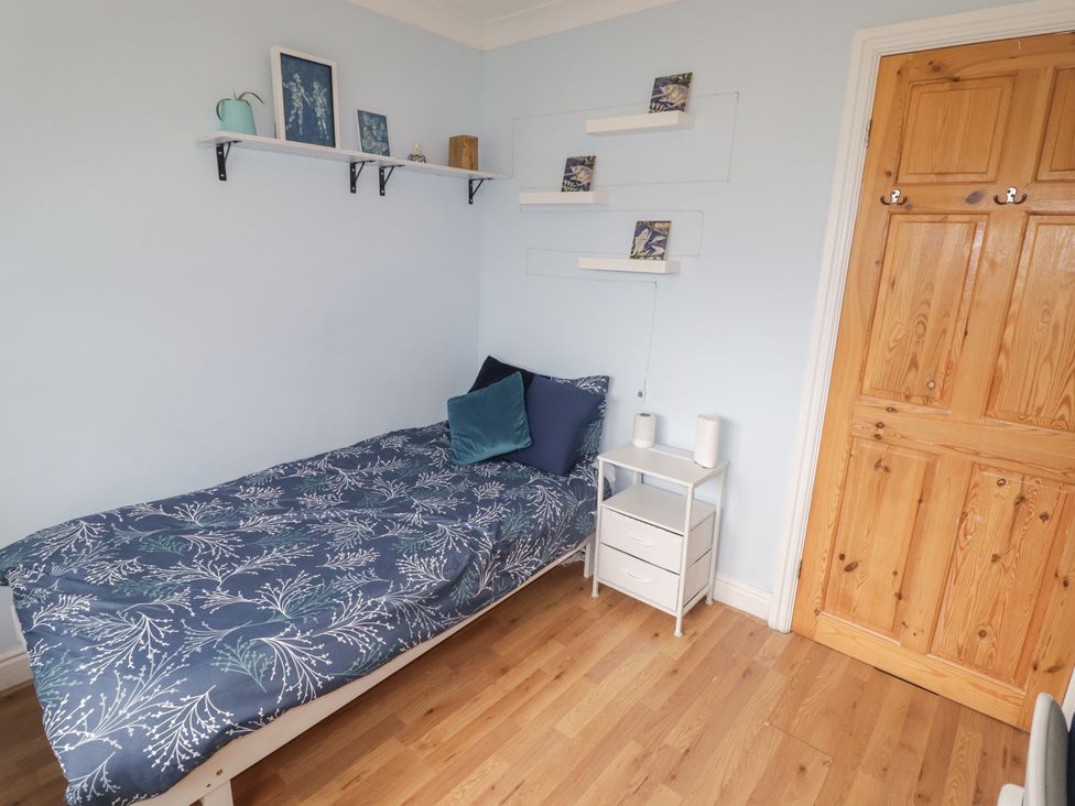A bedroom with a bed and shelf at 1 Rosemount Garden Villas Tenby