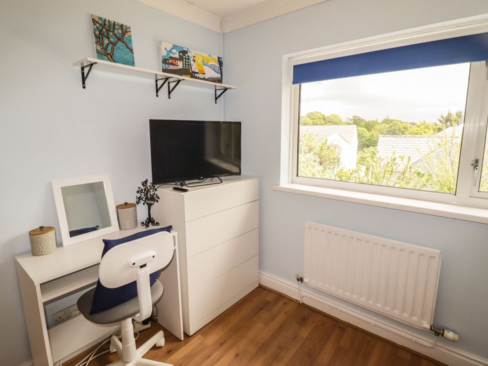 A bedroom with a desk and television at 1 Rosemount Garden Villas Tenby