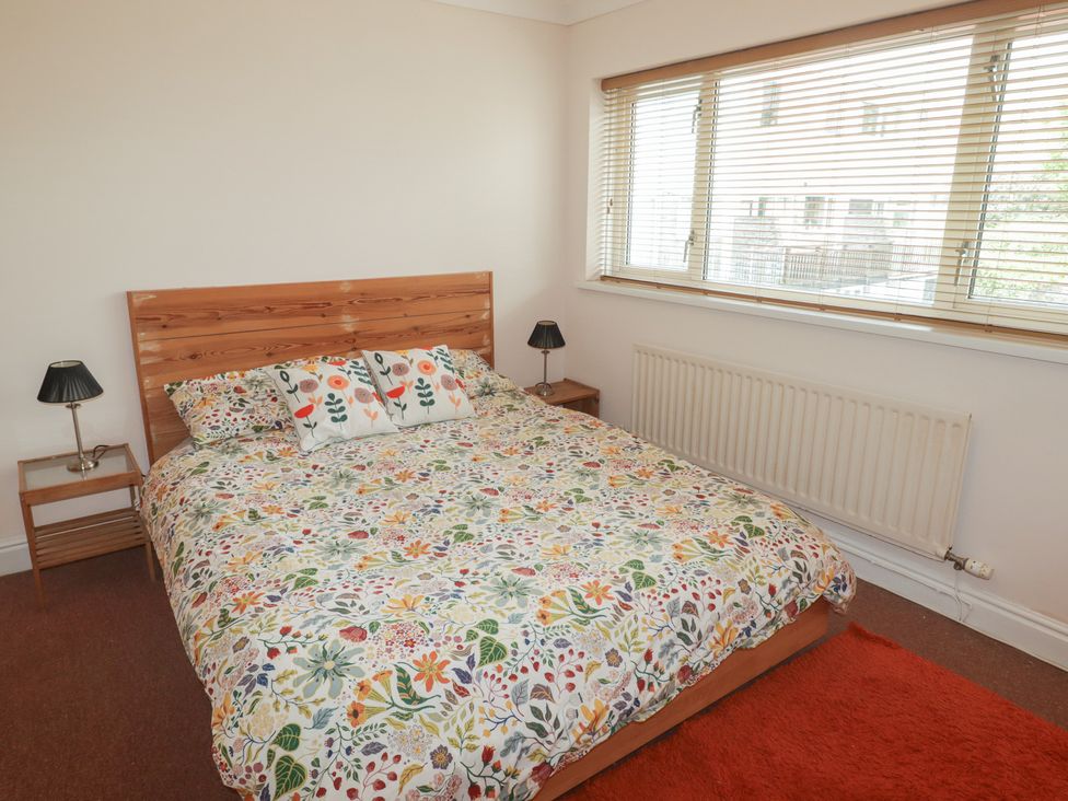 A bedroom with a bed and bedside tables at 1 Rosemount Garden Villas Tenby