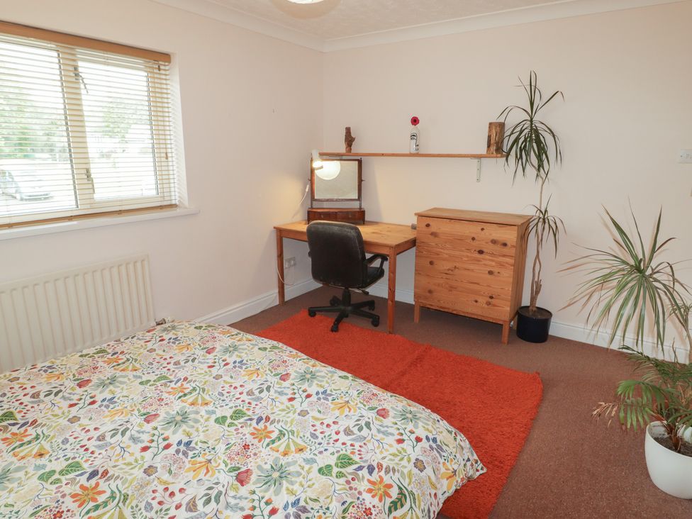 A bedroom with a desk and chair at 1 Rosemount Garden Villas in Tenby