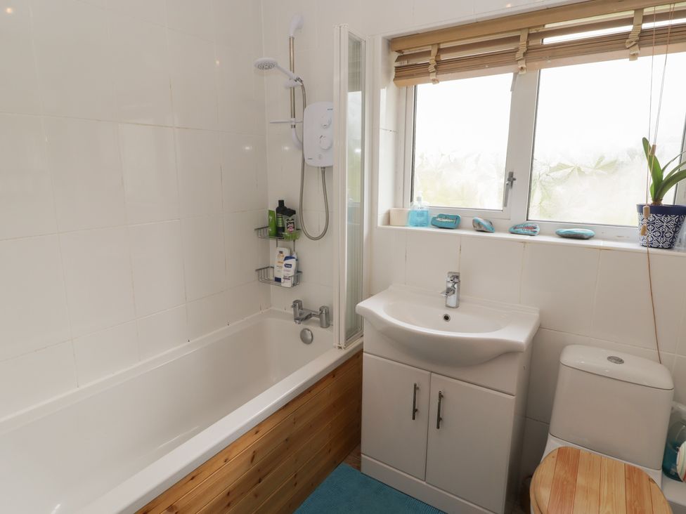 A bathroom with a bathtub and sink at 1 Rosemount Garden Villas Tenby