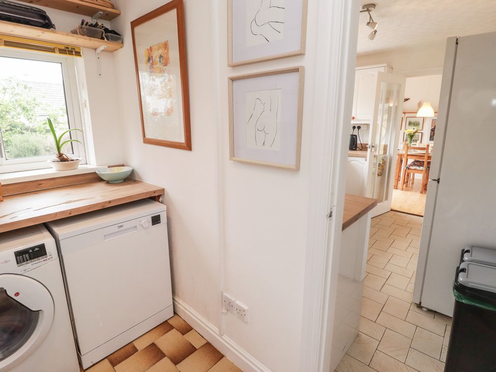 A kitchen with a washing machine and dishwasher at 1 Rosemount Garden Villas Tenby