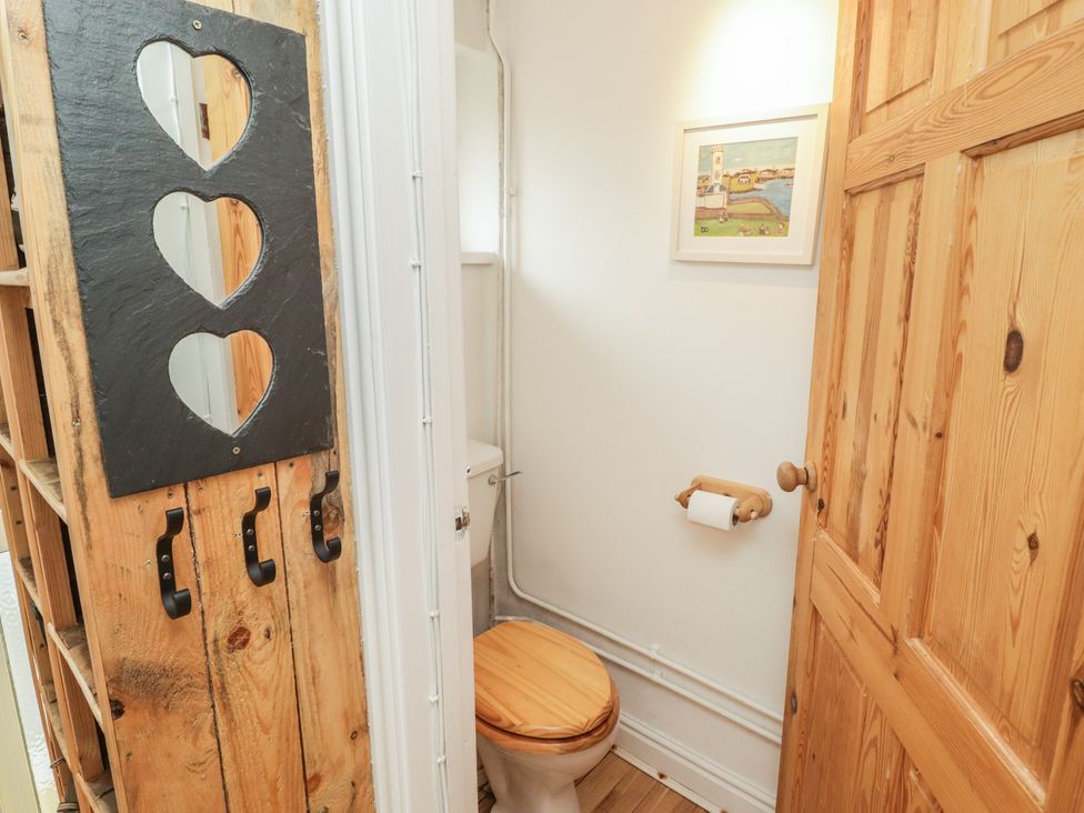 A bathroom featuring a toilet and wooden elements at 1 Rosemount Garden Villas Tenby