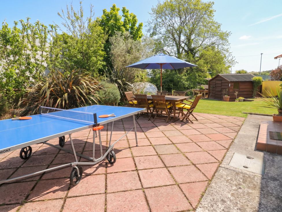 A garden with a ping pong table and seating area at 1 Rosemount Garden Villas Tenby