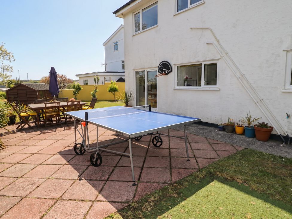 A garden with a table tennis table and outdoor dining set at 1 Rosemount Garden Villas Tenby