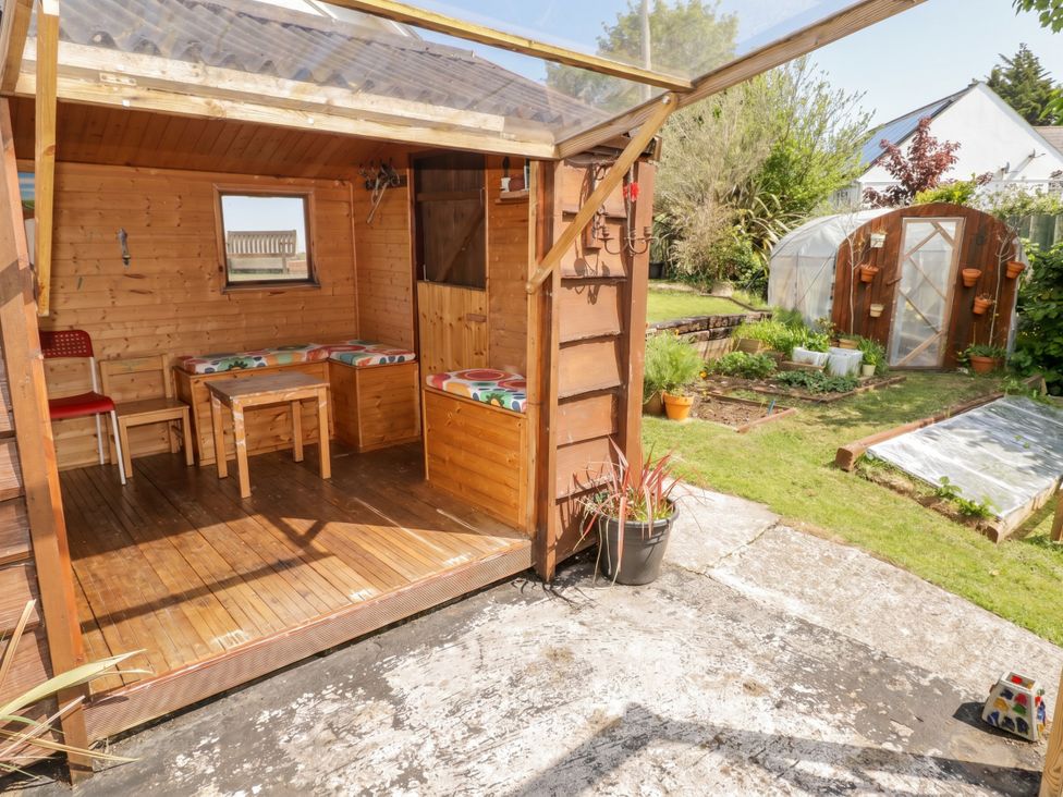 A garden with a wooden shed and plants at 1 Rosemount Garden Villas in Tenby