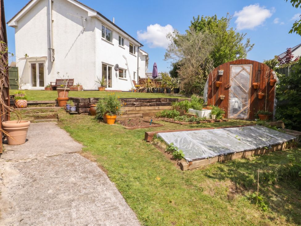A garden with plants and a greenhouse at 1 Rosemount Garden Villas in Tenby