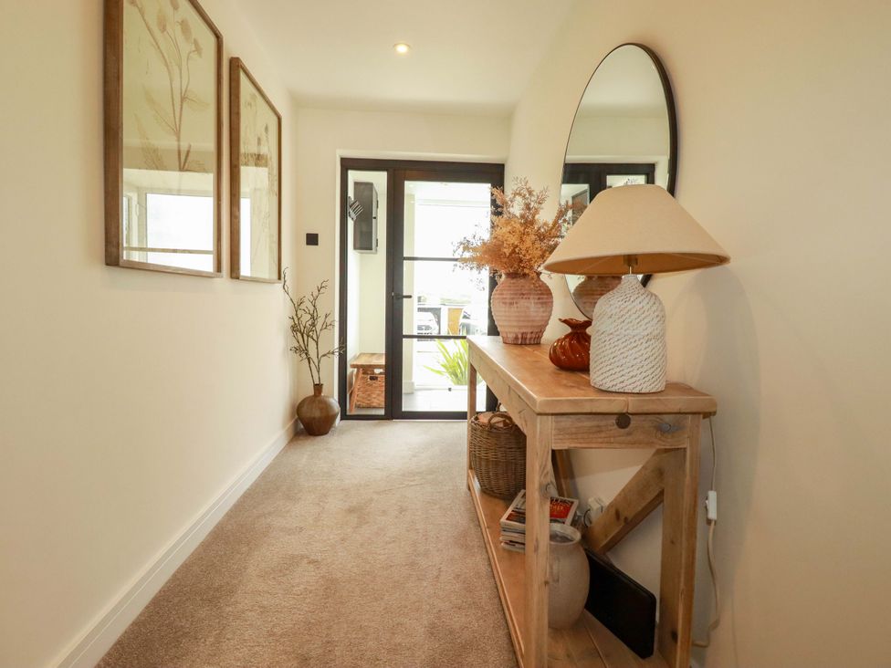 A hallway with a console table and decorative items at No.45 Whealgolden Drive in Newquay