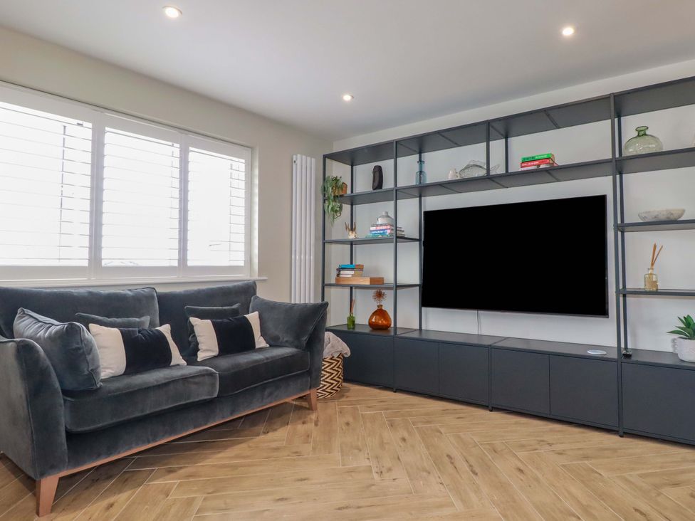 A living room with a sofa and shelves at No.45 Whealgolden Drive Newquay