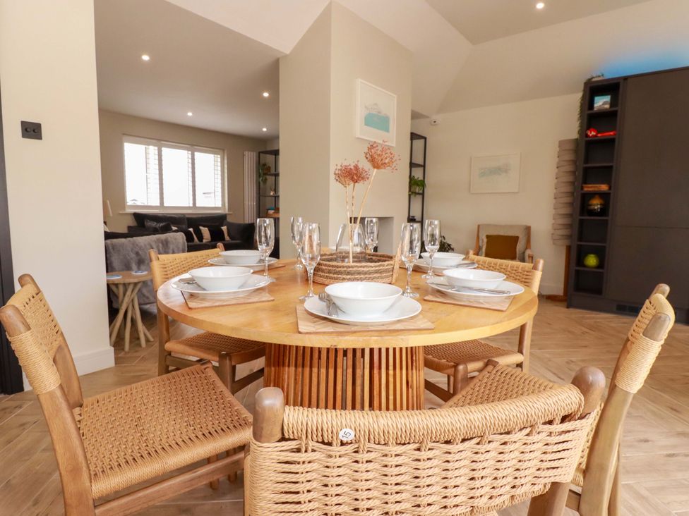 A dining room with a round table set for dinner at No.45 Whealgolden Drive in Newquay