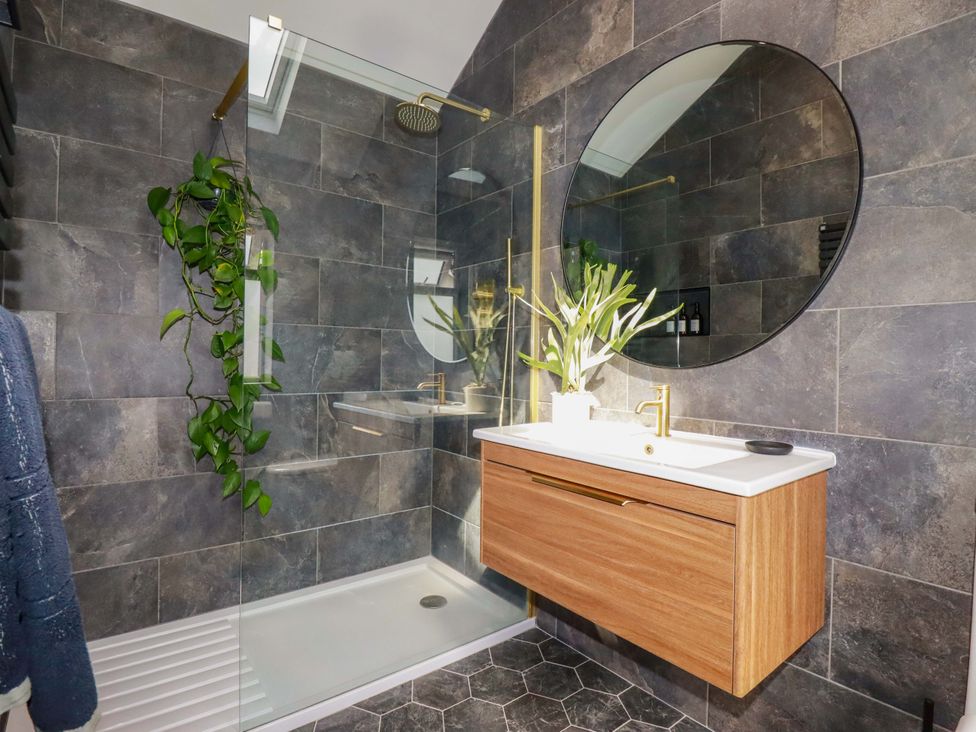 A bathroom featuring a shower, sink and mirror at No.45 Whealgolden Drive in Newquay