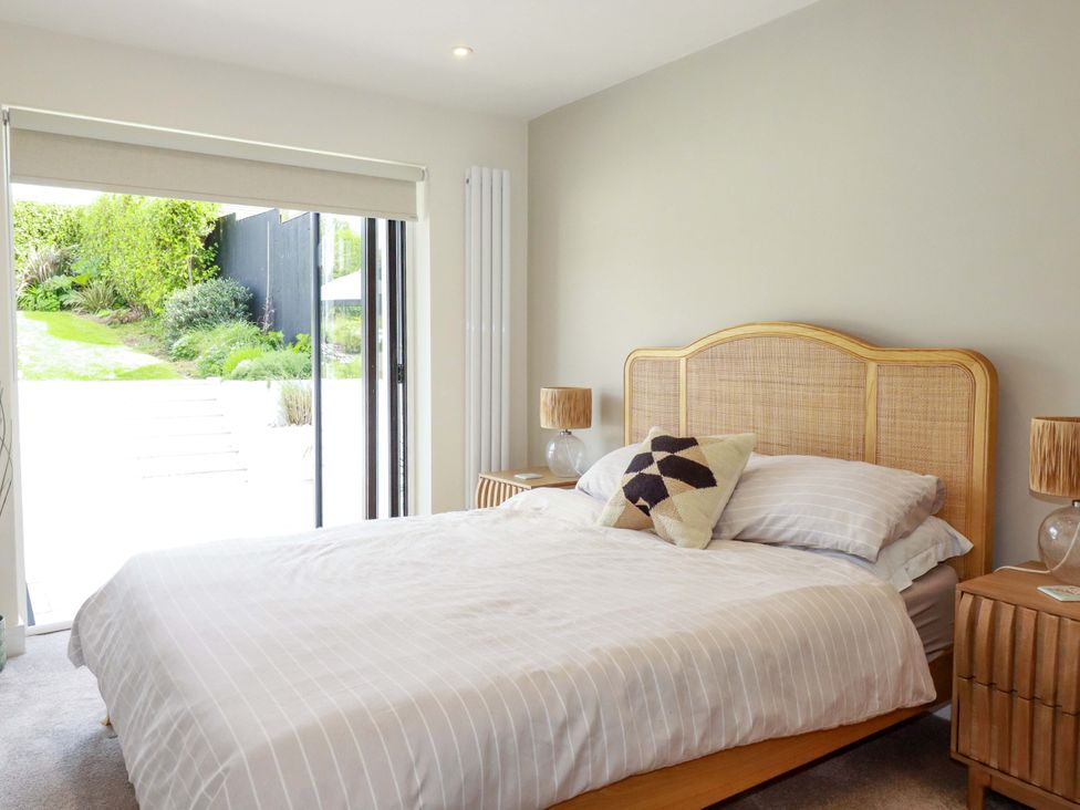 A bedroom with a bed and nightstands at No.45 Whealgolden Drive, Newquay